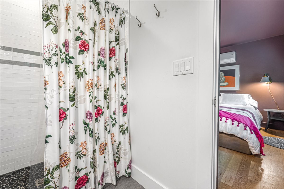 Your private bathroom features a charming floral shower curtain and fresh linens, creating a cozy retreat after exploring the city.