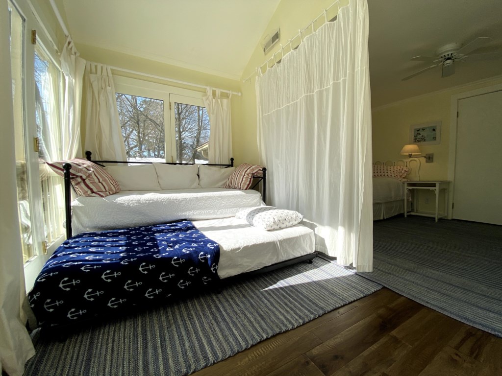 Primary bedroom sleeping alcove with daybed & trundle, curtains for visual privacy.