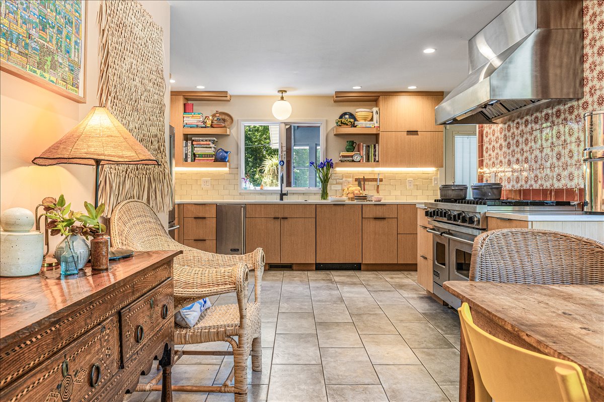 Your dream kitchen awaits with warm wood cabinets, modern appliances, and cozy wicker seating perfect for morning coffee conversations.