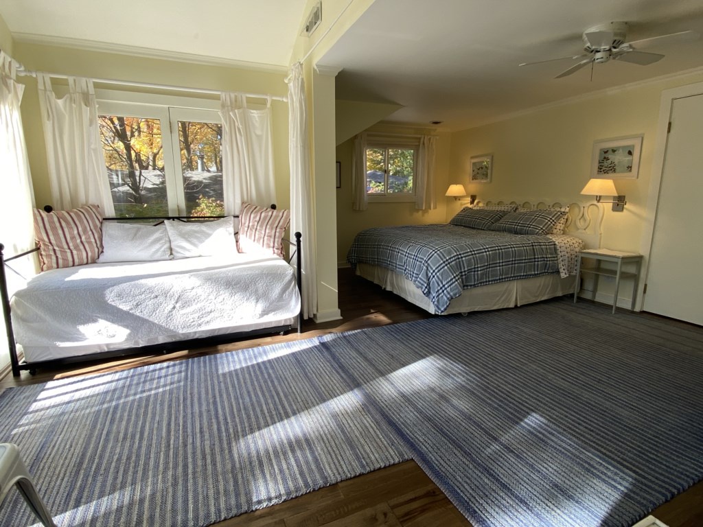 Primary bedroom set up with king bed and daybed/trundle (2 twin beds) in front alcove. Curtains sepa