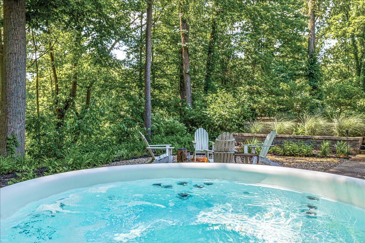 Soak in your private hot tub surrounded by lush forest canopy, where bubbling warmth meets nature's tranquil embrace.