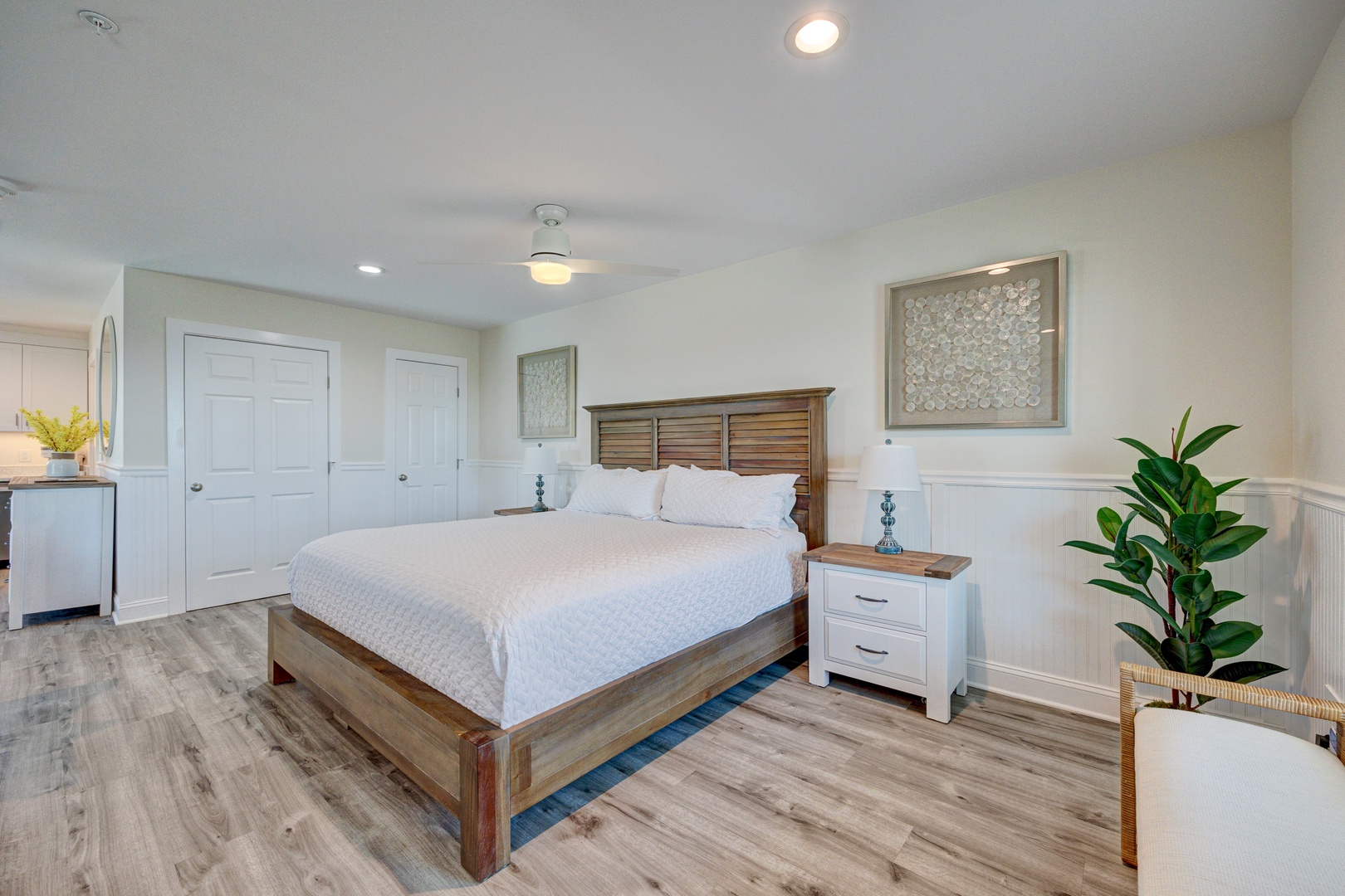Unwind in your beautifully appointed bedroom featuring a plush bed, elegant wood furnishings, and calming coastal touches for the perfect night's rest.