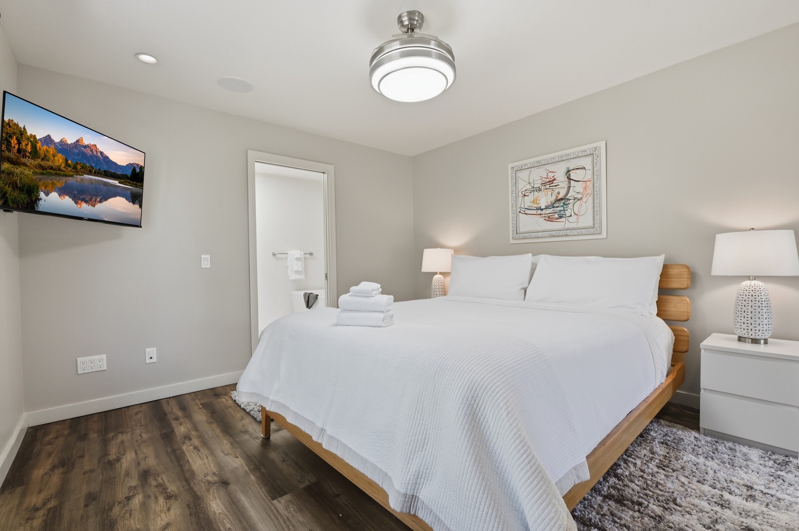 Sink into crisp white linens in your serene bedroom, complete with smart TV and thoughtful touches for ultimate relaxation.