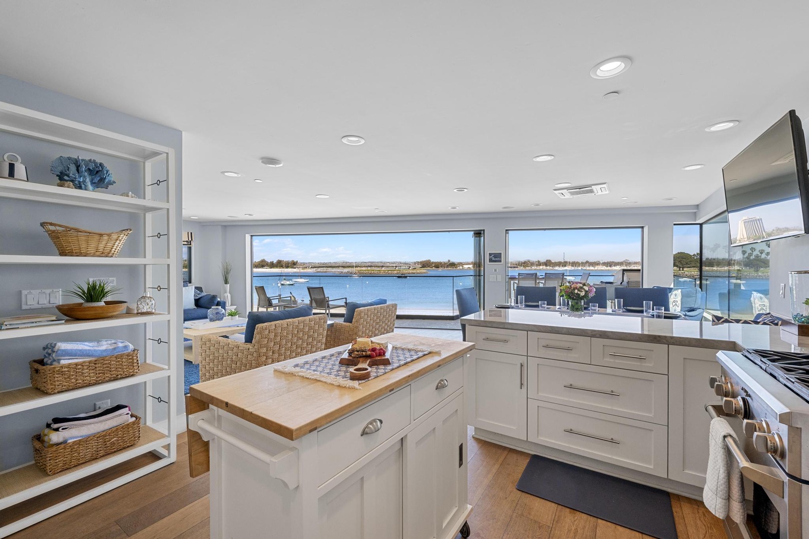 Your gourmet kitchen invites you to create culinary delights while gazing at peaceful waterfront vistas through expansive windows. Natural light, coastal charm, and modern conveniences blend seamlessly in this beautiful open space.