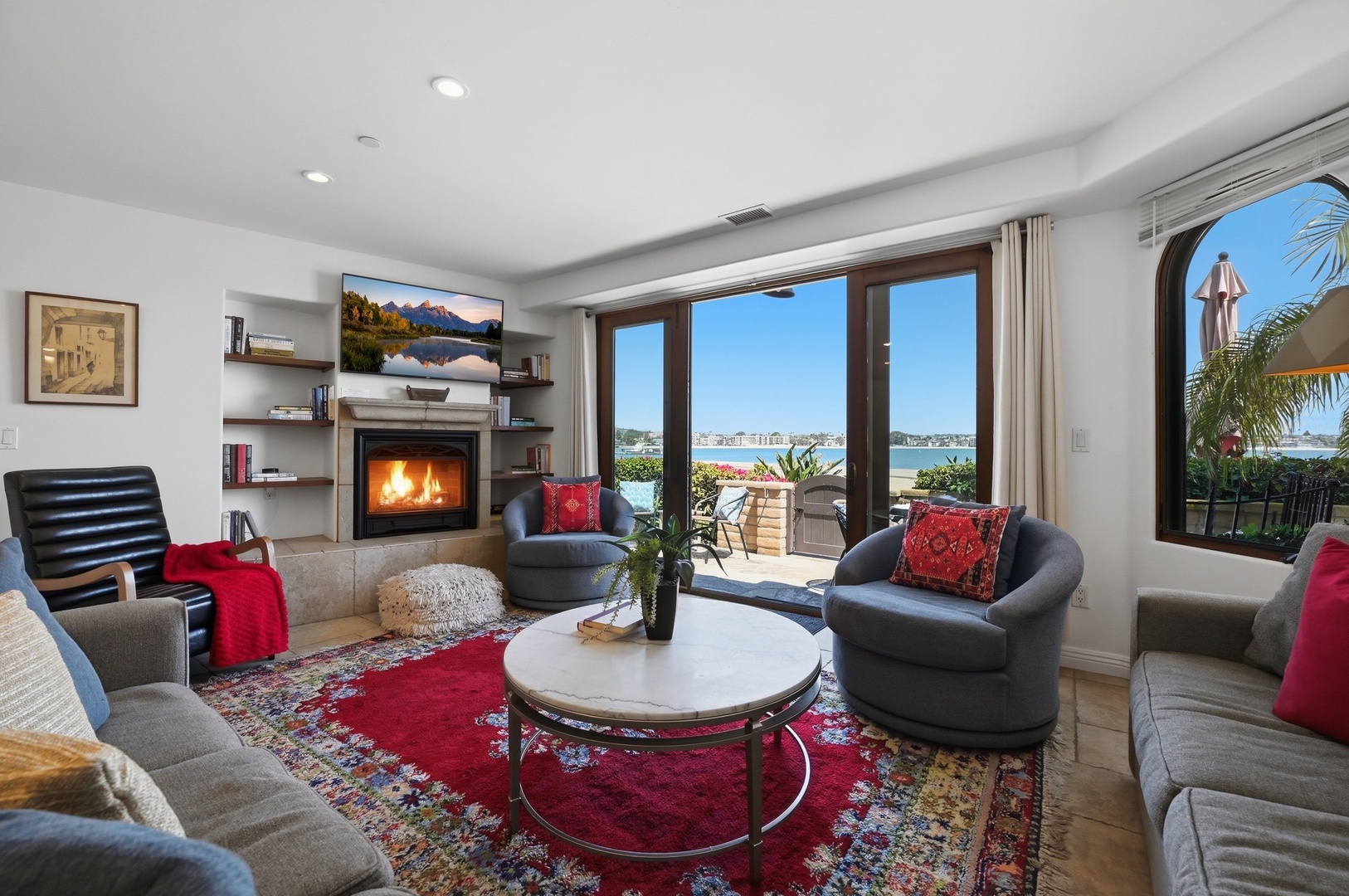 Sink into plush seating by your crackling fireplace while enjoying Mission Bay views through floor-to-ceiling windows in this elegant living space.