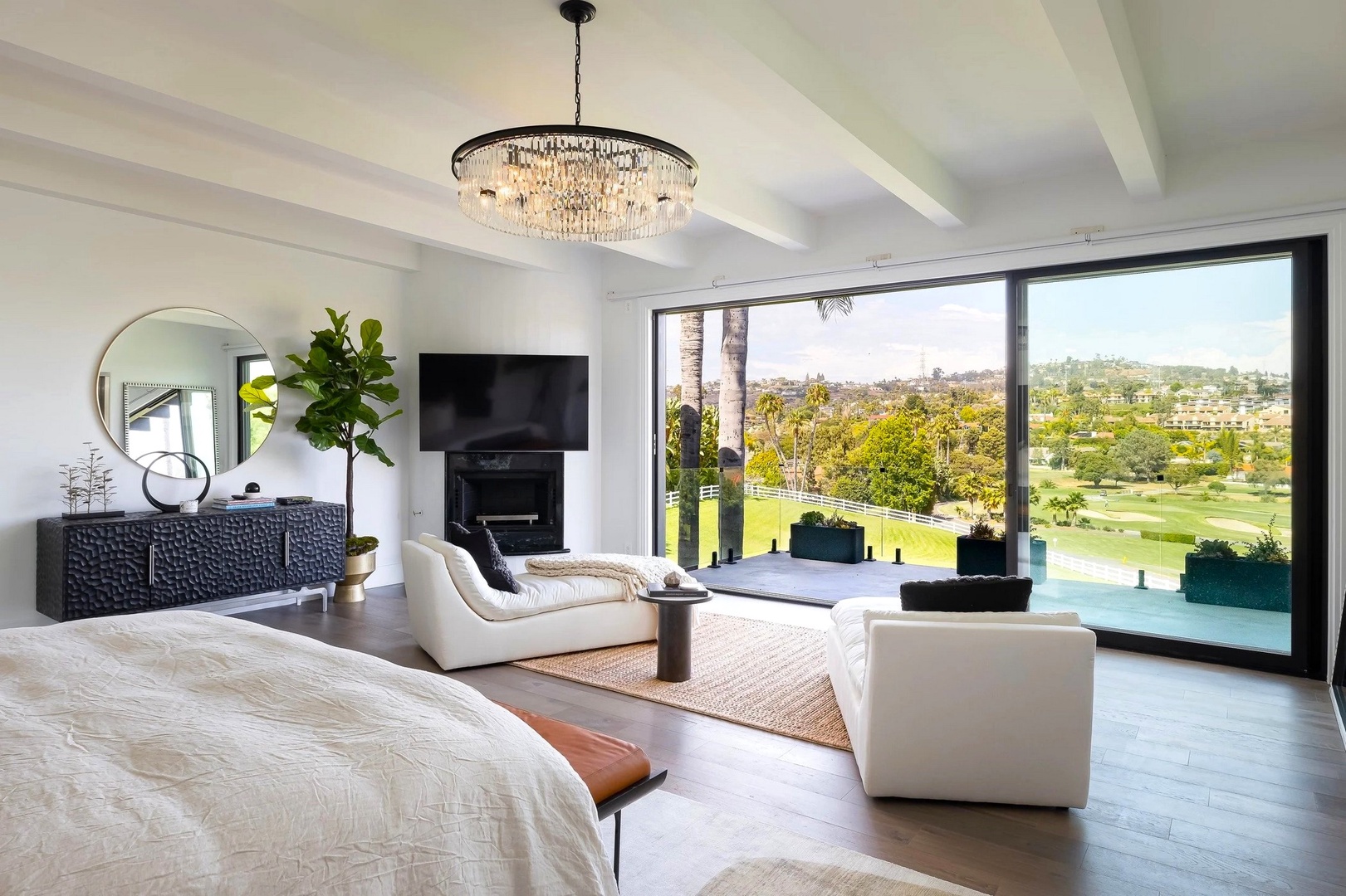 Unwind in your luxurious bedroom suite with crystal chandelier, fireplace, and stunning golf course views through floor-to-ceiling windows.