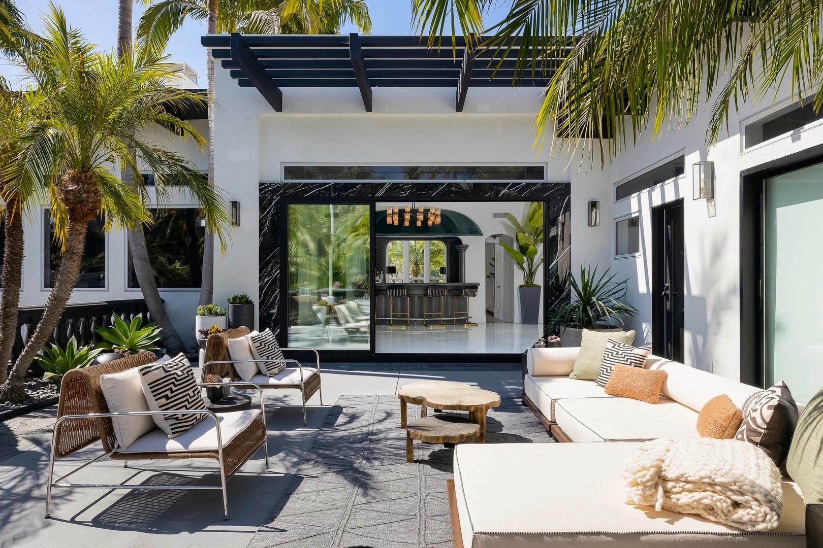 Modern villa with tropical paradise views, featuring an outdoor terrace seamlessly connected to elegant interior spaces.