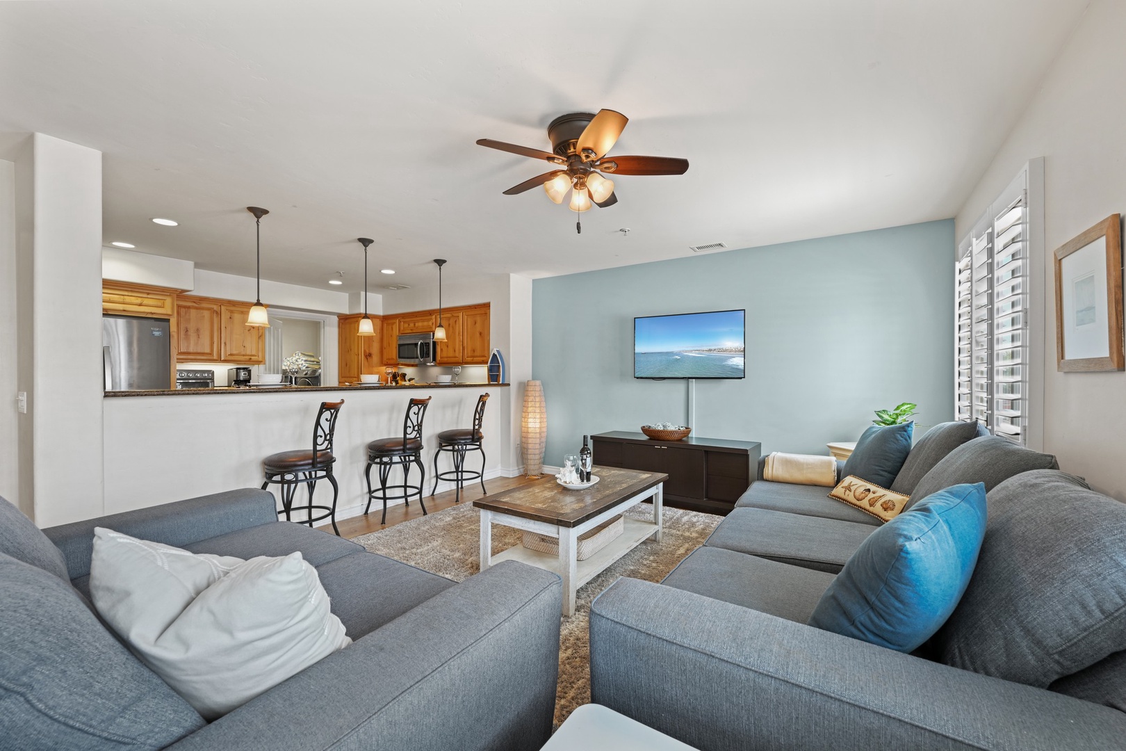 Living area with ceiling fan and TV
