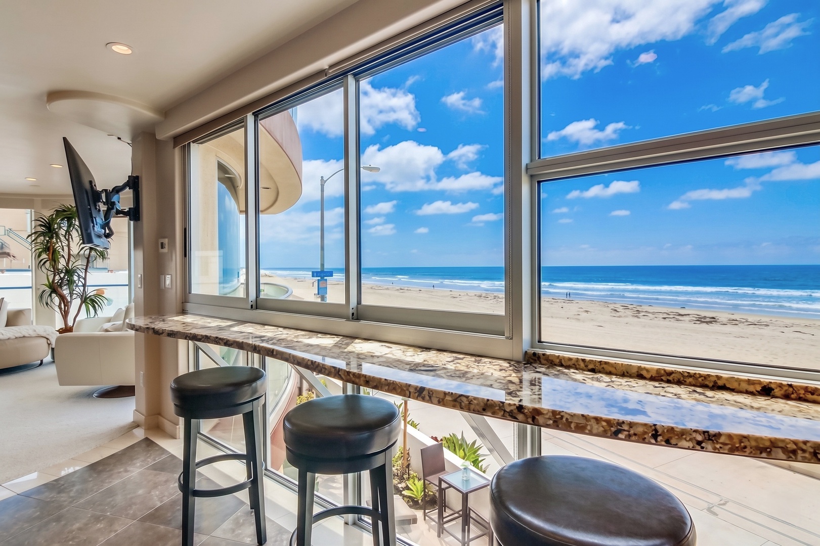 Pull up a seat at your sleek bar counter and take in unobstructed ocean views through floor-to-ceiling windows, where waves meet endless blue sky.