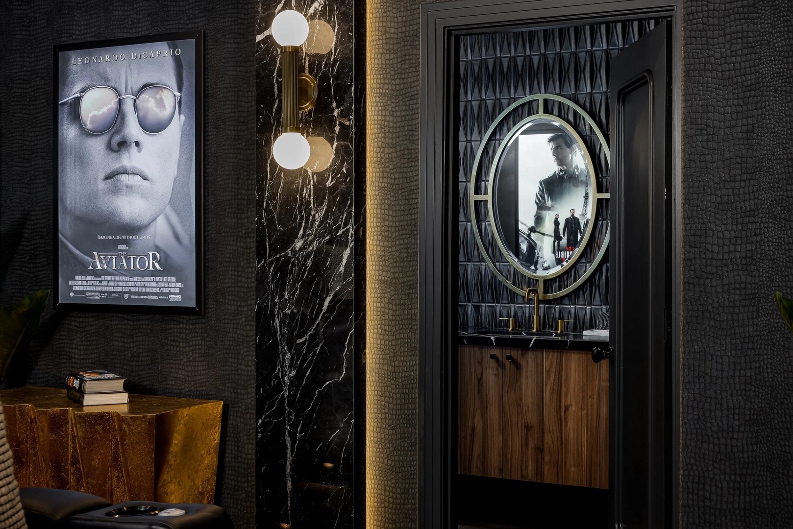 Your sophisticated movie theatre room features dramatic black marble walls, warm brass lighting, and elegant vanity details for wonderful entertainment