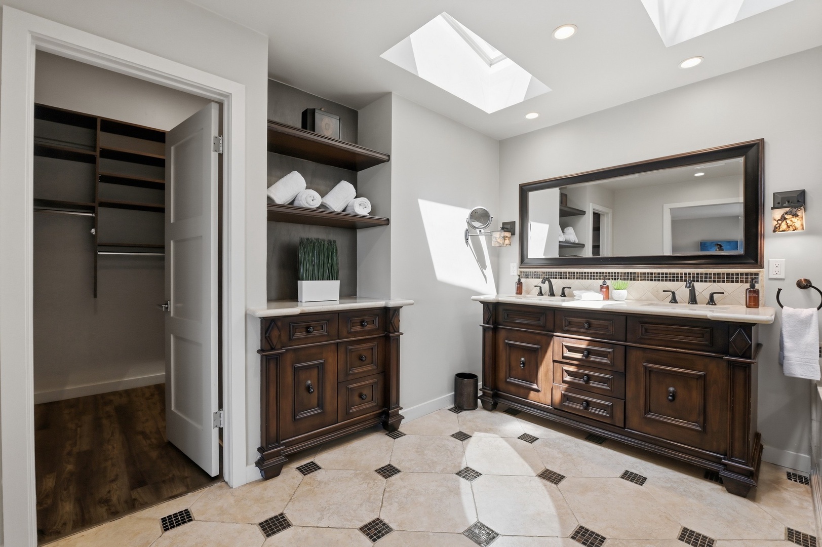 Pamper yourself in this spa-like bathroom with dual vanities, skylights flooding natural light, and plush towels awaiting your arrival.