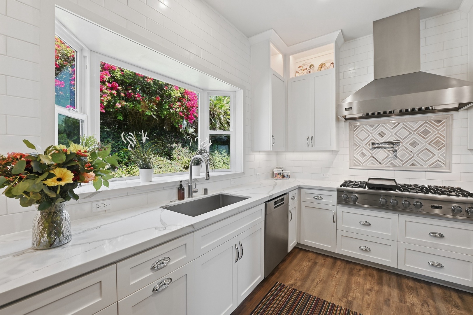 Your bright kitchen features marble counters, stainless appliances, and garden views through the large window for inspiring meal prep.