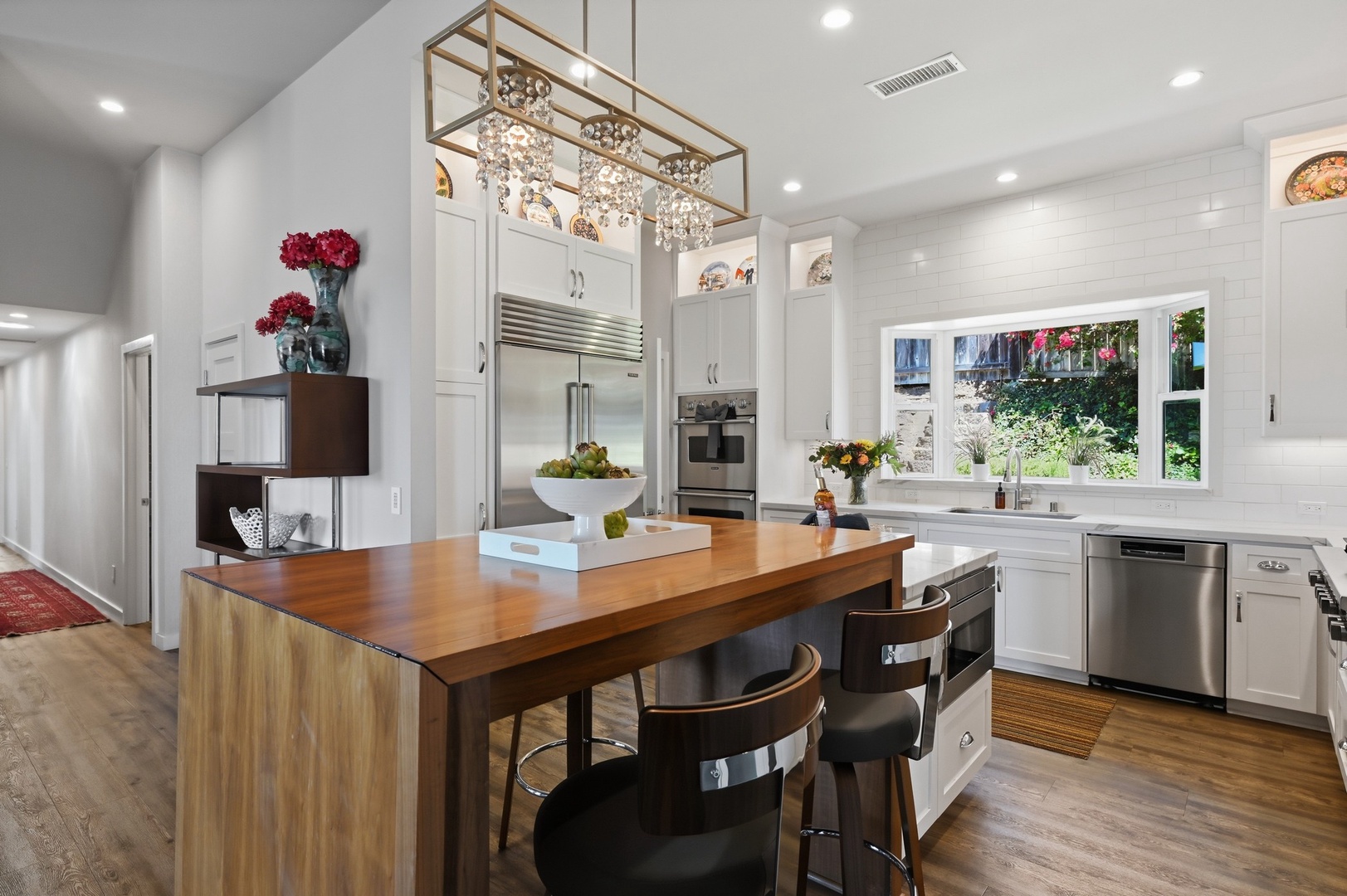 Your gourmet kitchen awaits with gleaming appliances, elegant lighting, and a stunning wood island perfect for cooking memorable meals together.
