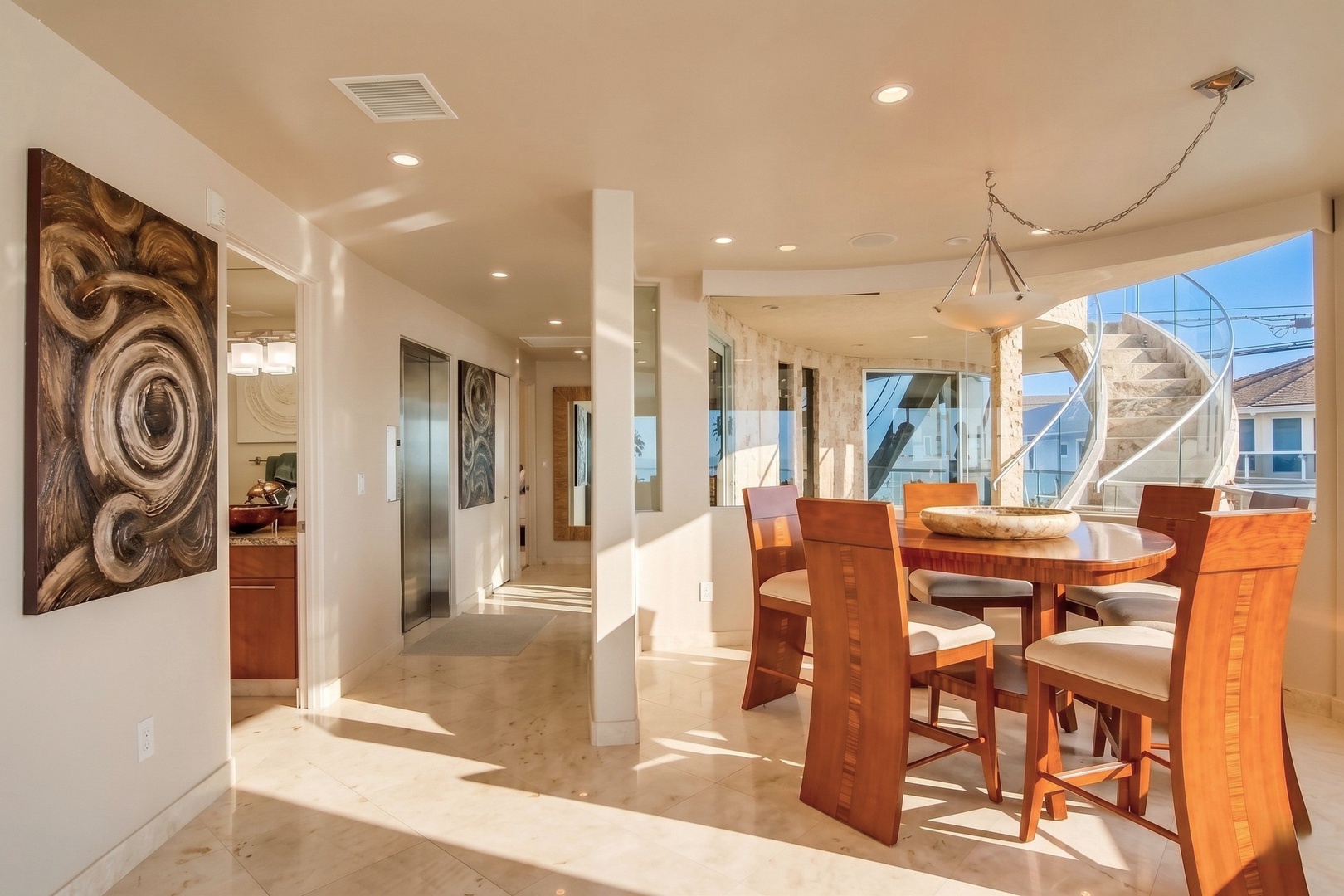 Sunlit dining and entryway flow together, offering space to gather over meals, with large windows framing the outside and elegant finishes throughout your stay.