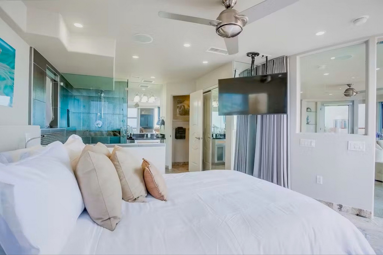 Crisp white linens, TV and ceiling fan for comfort