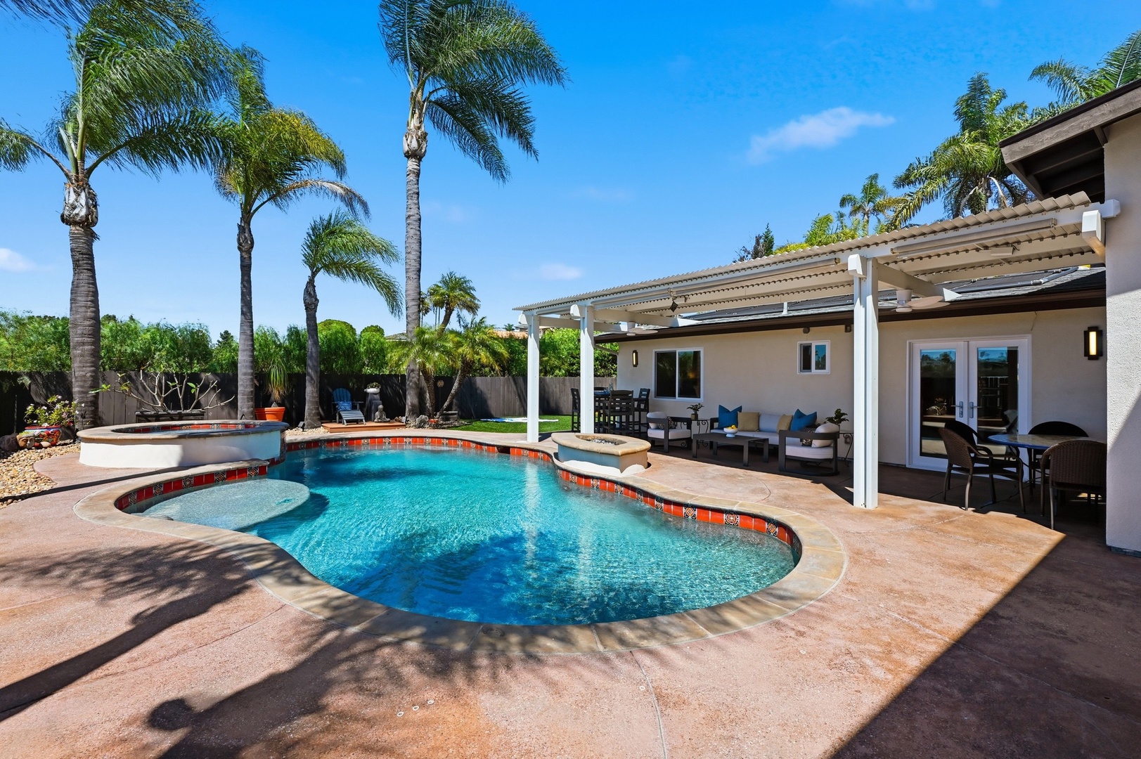 Dive into your private oasis with sparkling pool, tropical palms, and covered patio perfect for sunny days and starlit evenings.