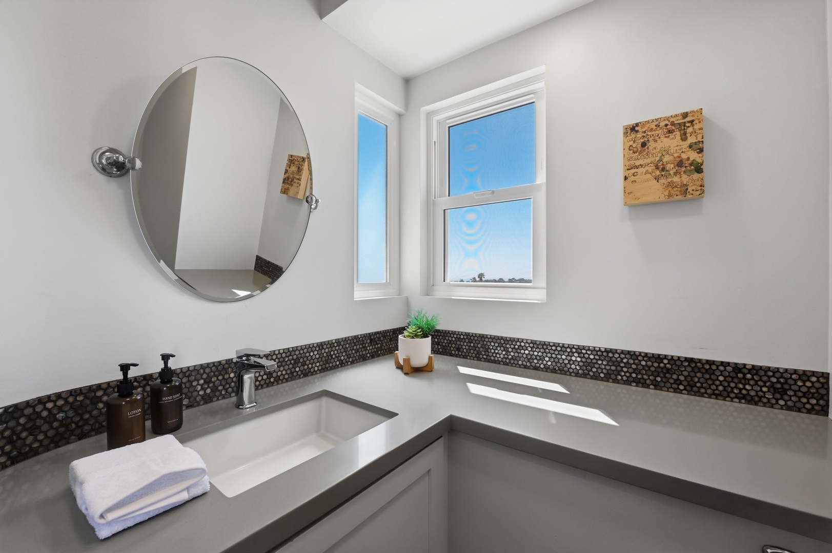 Step into your modern bathroom featuring sleek quartz countertops and stylish mosaic backsplash, where natural light streams through windows.