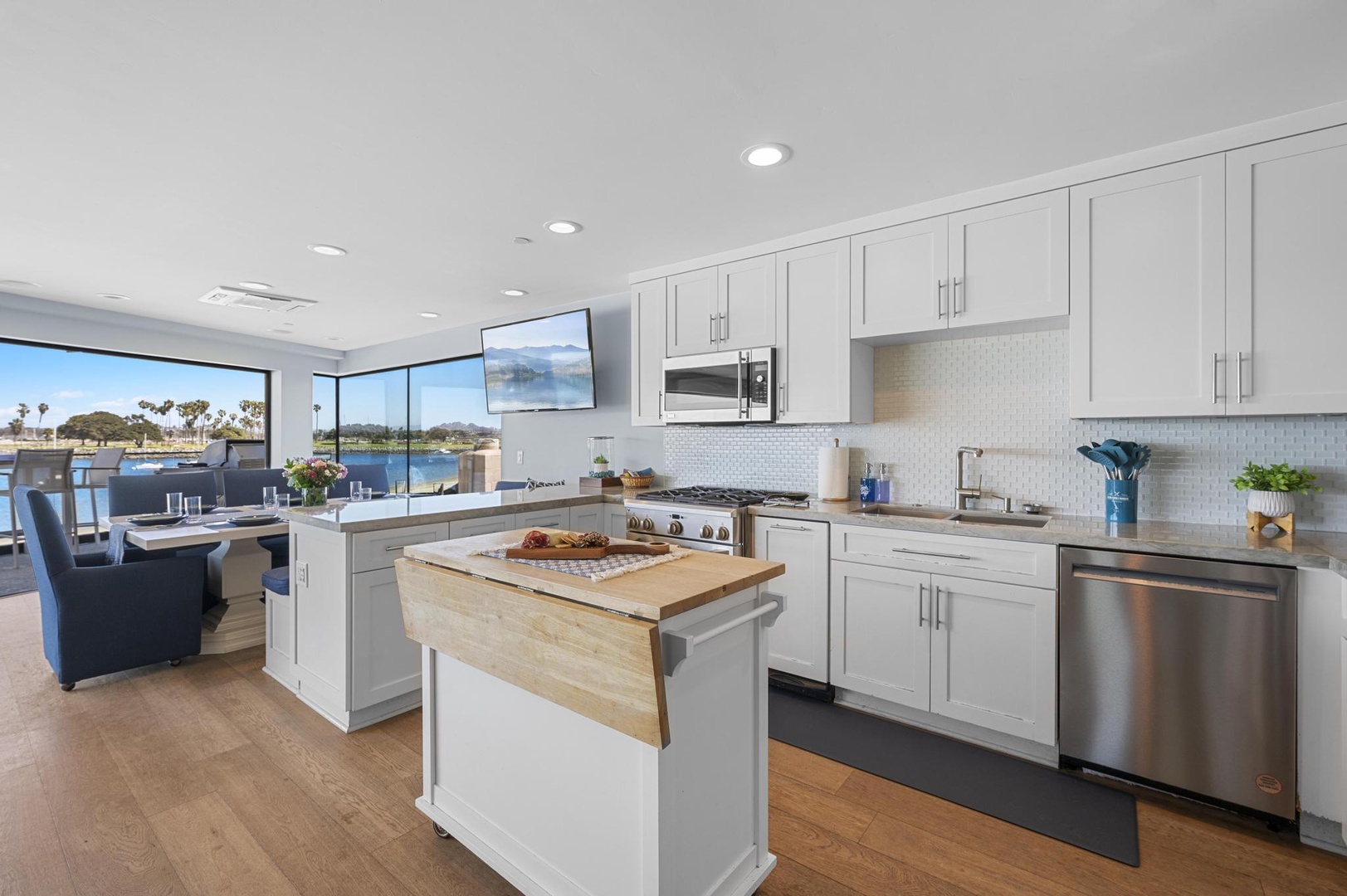 Cook meals in your bright, waterfront kitchen with stainless steel appliances, ample counter space, and sweeping lake views through expansive windows.