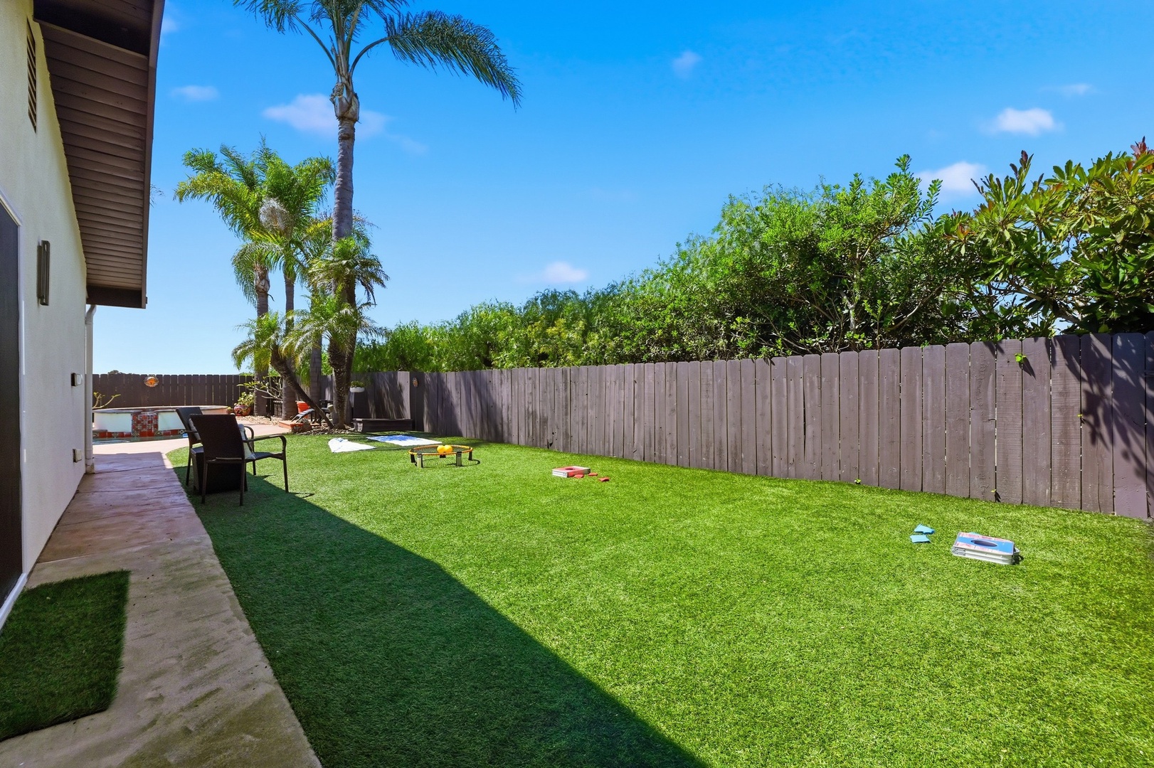 Your private backyard oasis awaits with lush green lawn perfect for games, relaxation, and soaking up the tropical sunshine.