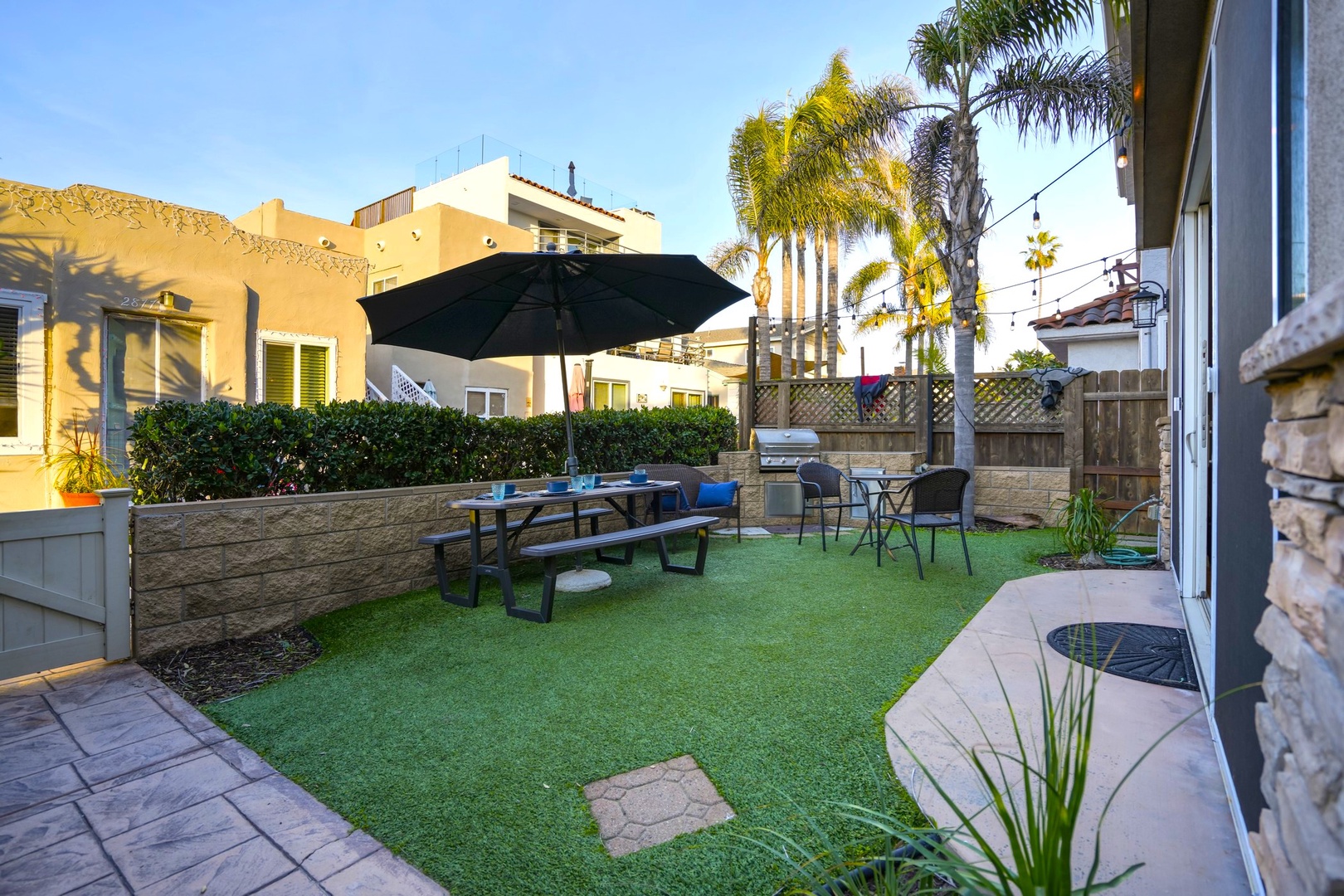 Gated front patio with BBQ and dining table