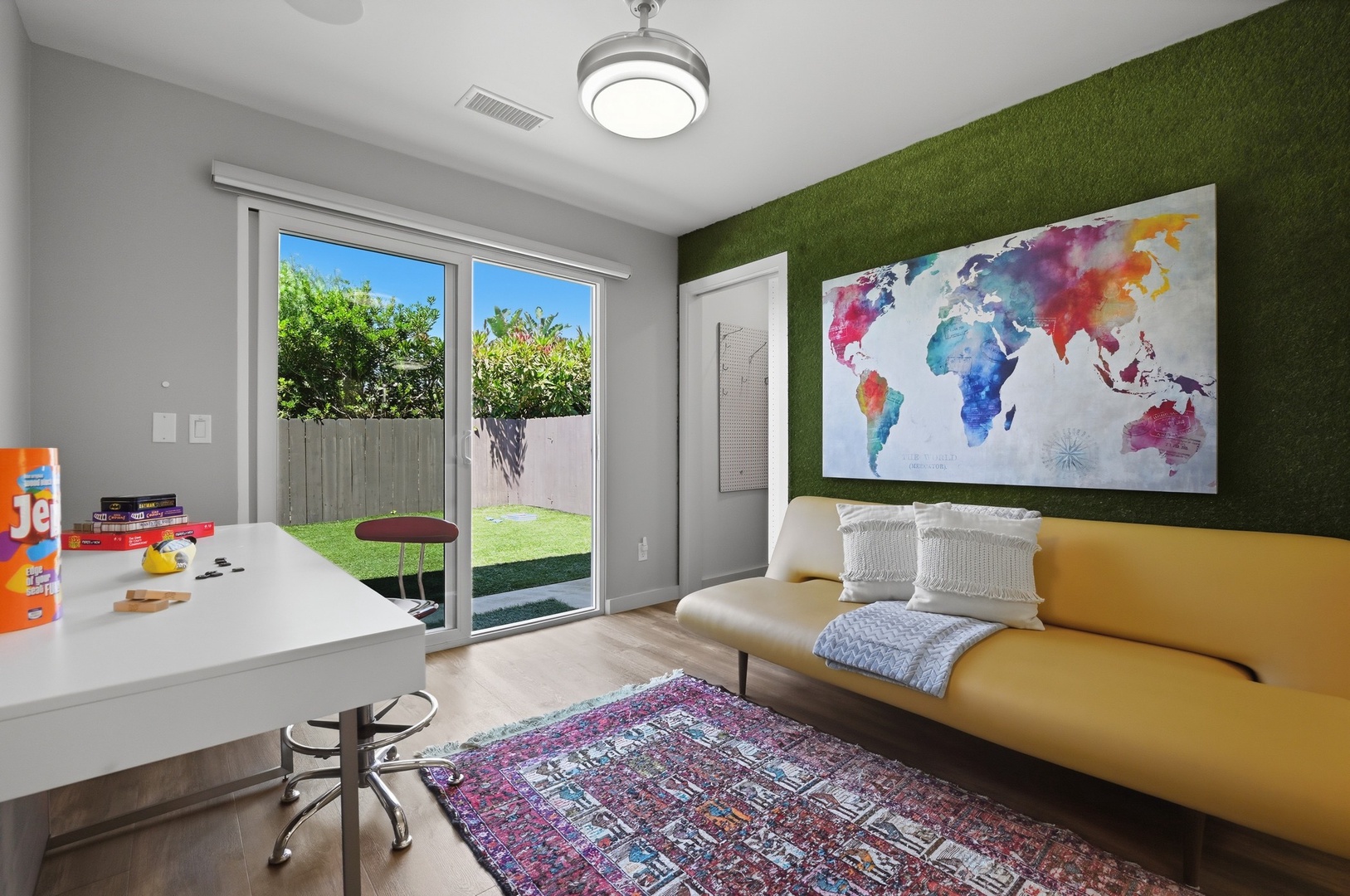 Your creative workspace features vibrant decor, a bold world map, and desk space overlooking the private garden.