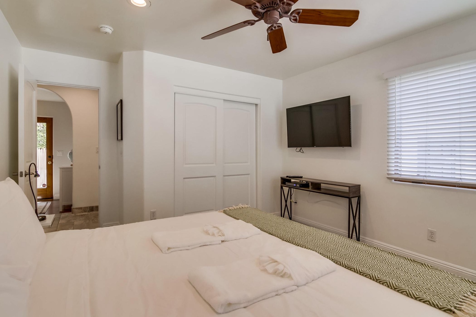 Features a ceiling fan and TV
