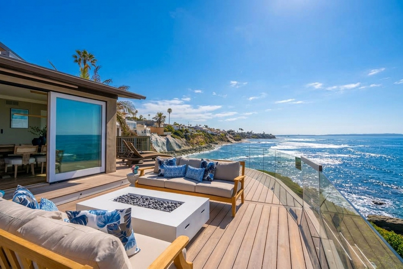 An oceanfront deck with a fire pit and lounge seating