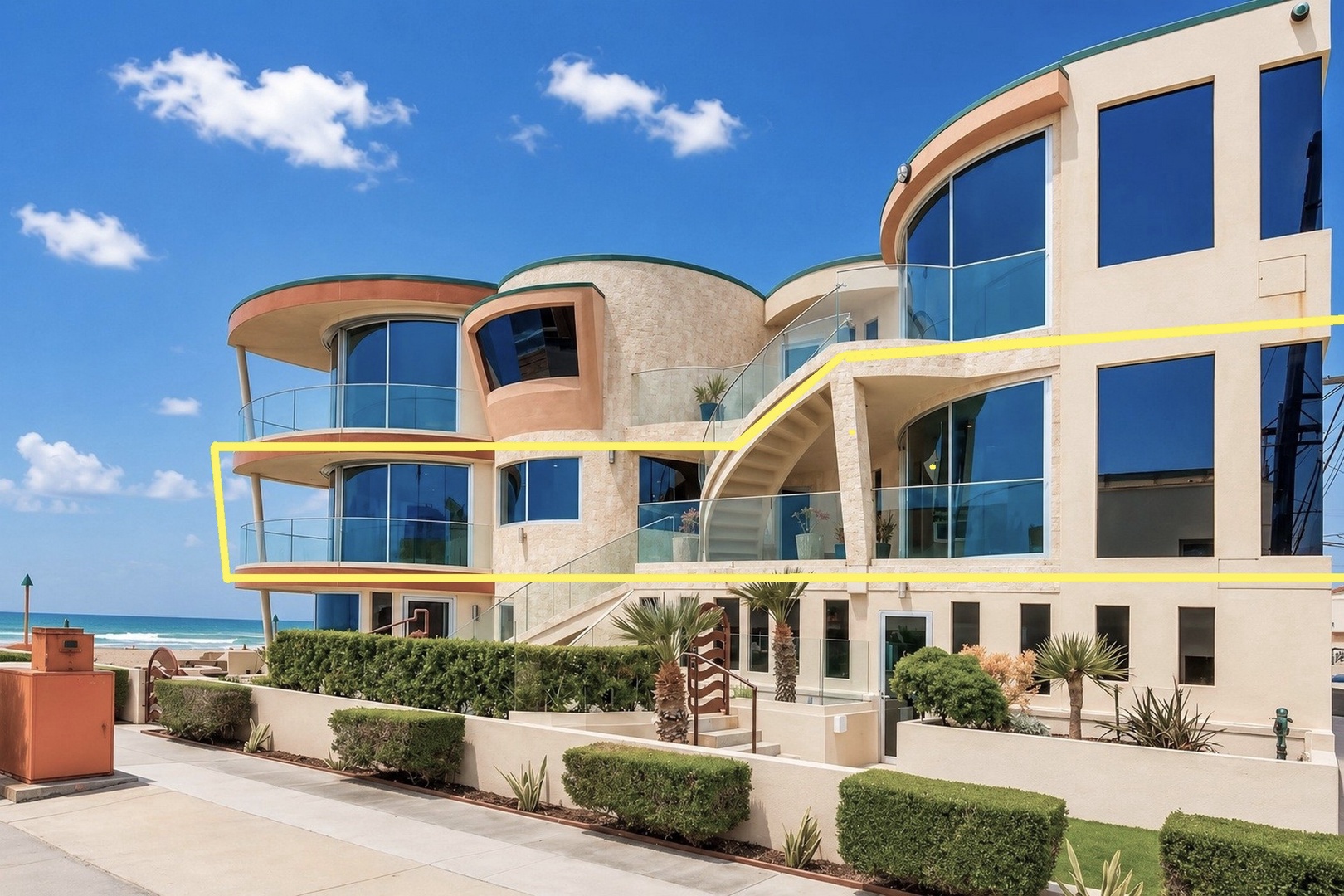 This stunning beachfront property features striking modern architecture with curved glass walls and spacious balconies overlooking the ocean, offering direct access to the sand and surf.