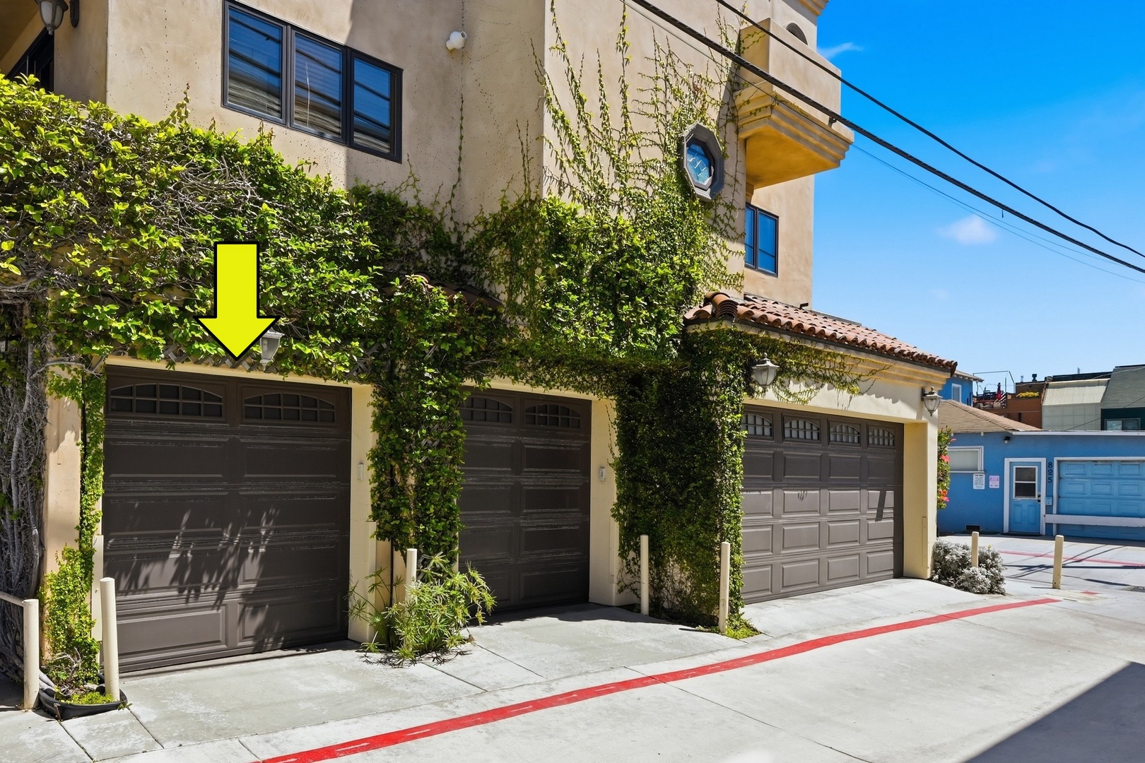 Charming ivy-covered property facade with multiple garage spaces and distinctive architectural details in a peaceful residential setting.