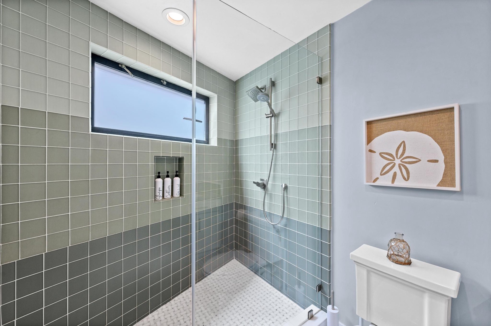 Step into your coastal-inspired spa shower with soothing sage tiles, rainfall head, and thoughtful built-in niche—your personal retreat for washing away the day.