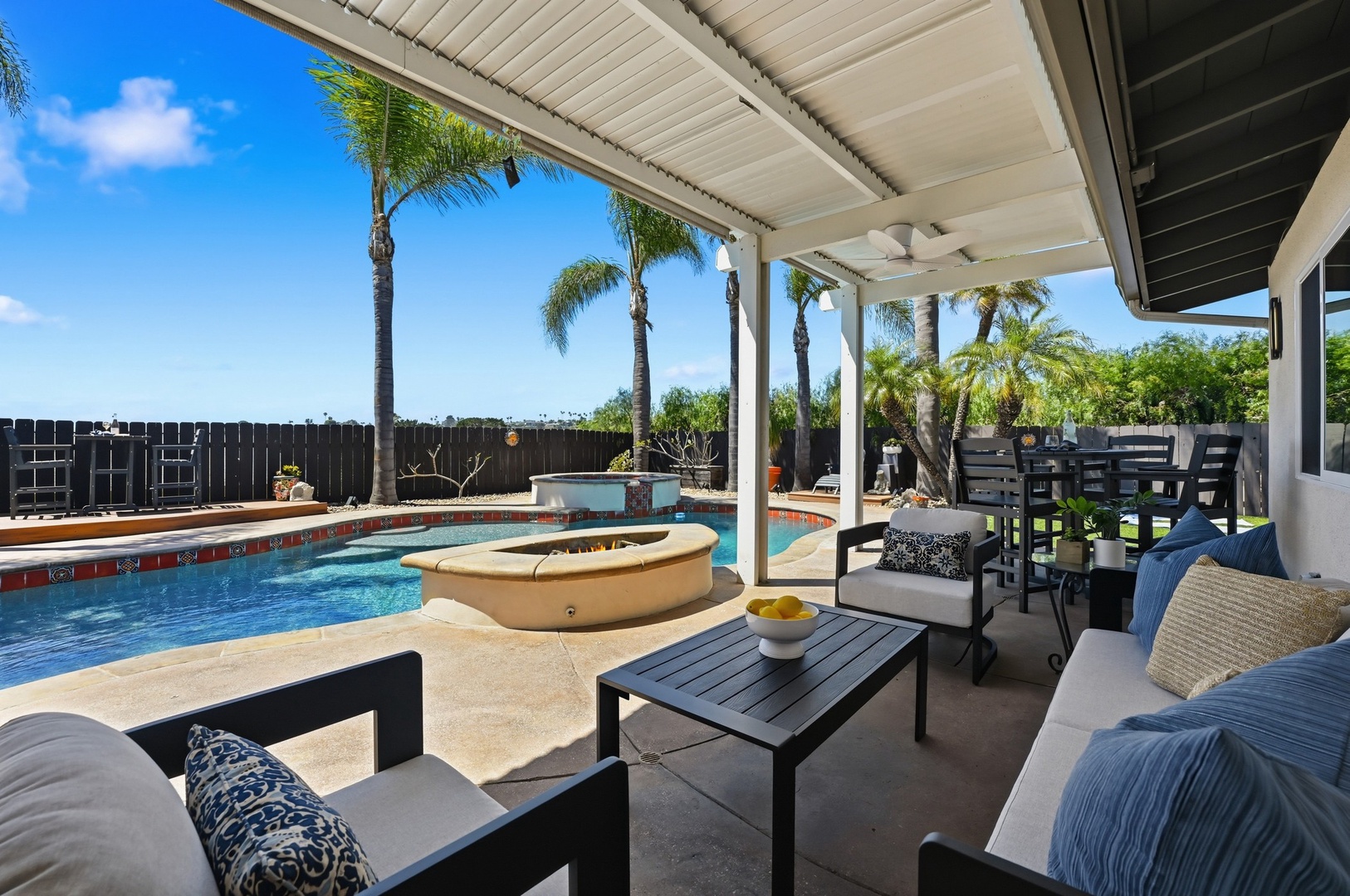 Your private poolside retreat awaits with comfortable lounge seating overlooking sparkling waters and swaying palms under sunny skies.