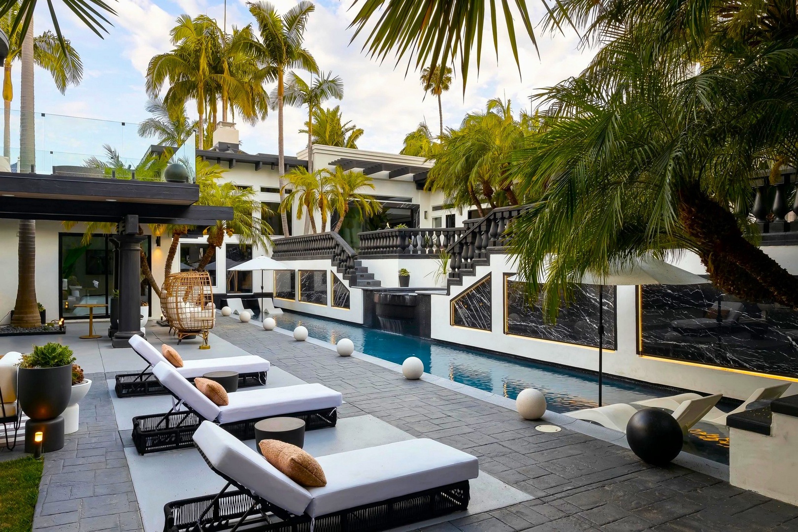 Luxurious poolside paradise with plush loungers and swaying palms creates your perfect tropical retreat.
