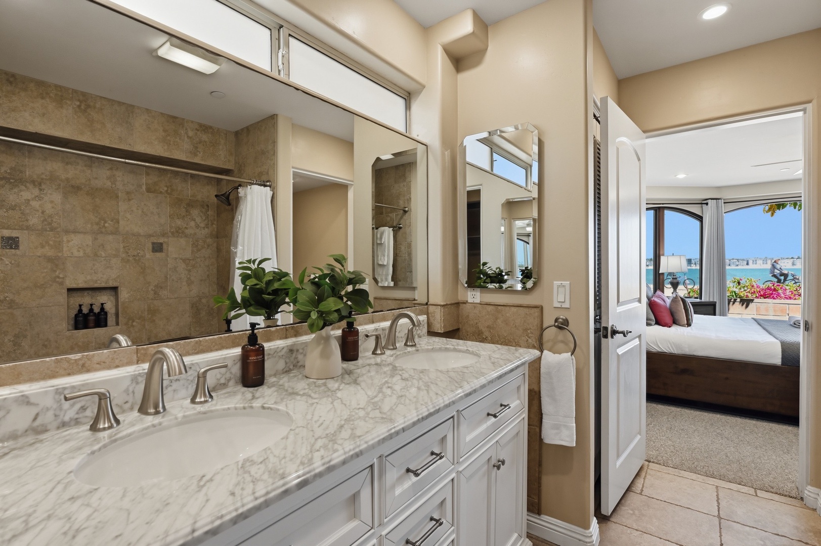 Pamper yourself in this luxurious ensuite with marble countertops and elegant dual vanities overlooking your ocean-view bedroom.