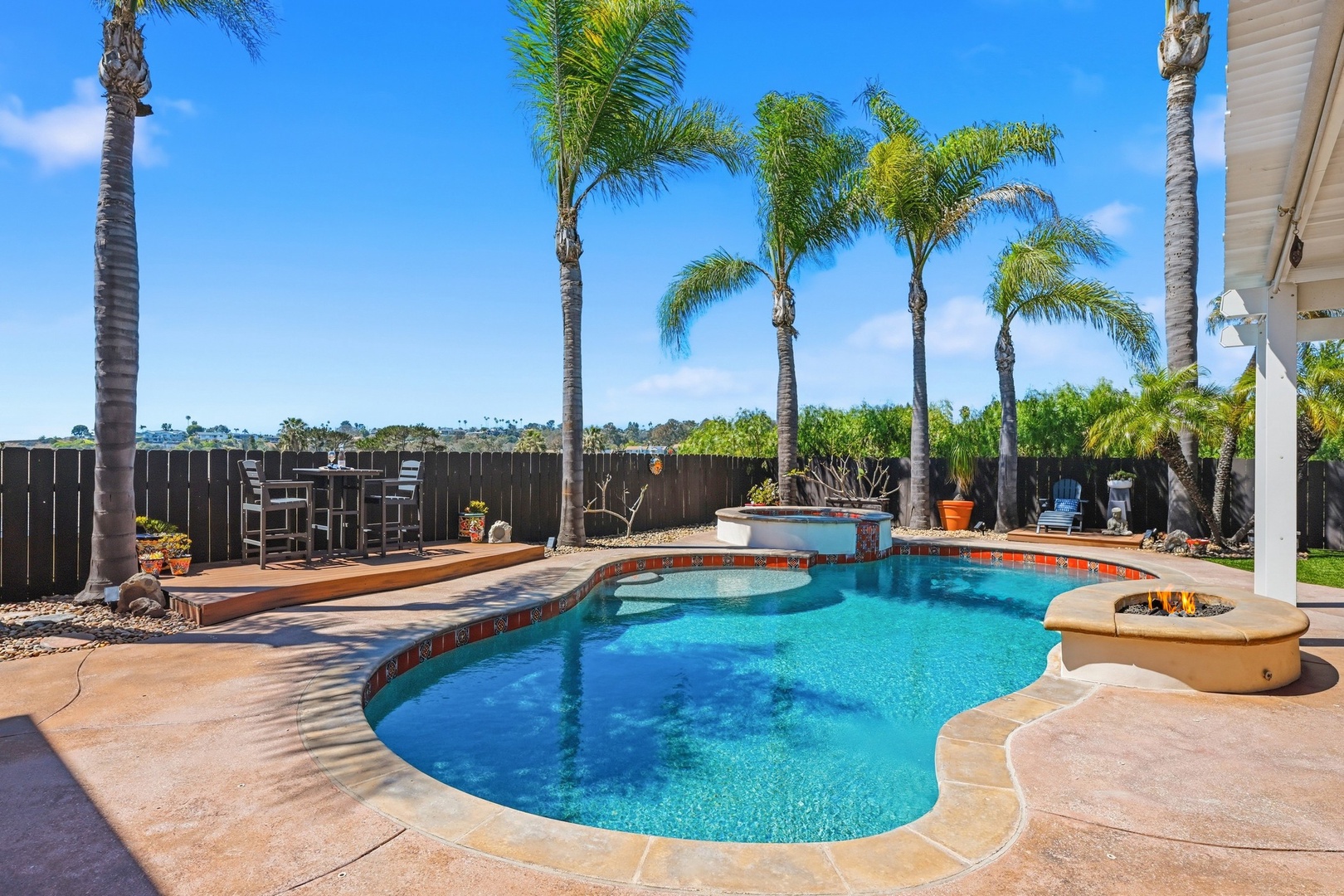 Your private tropical oasis awaits with a sparkling pool surrounded by swaying palms and cozy fire pit for evening relaxation.