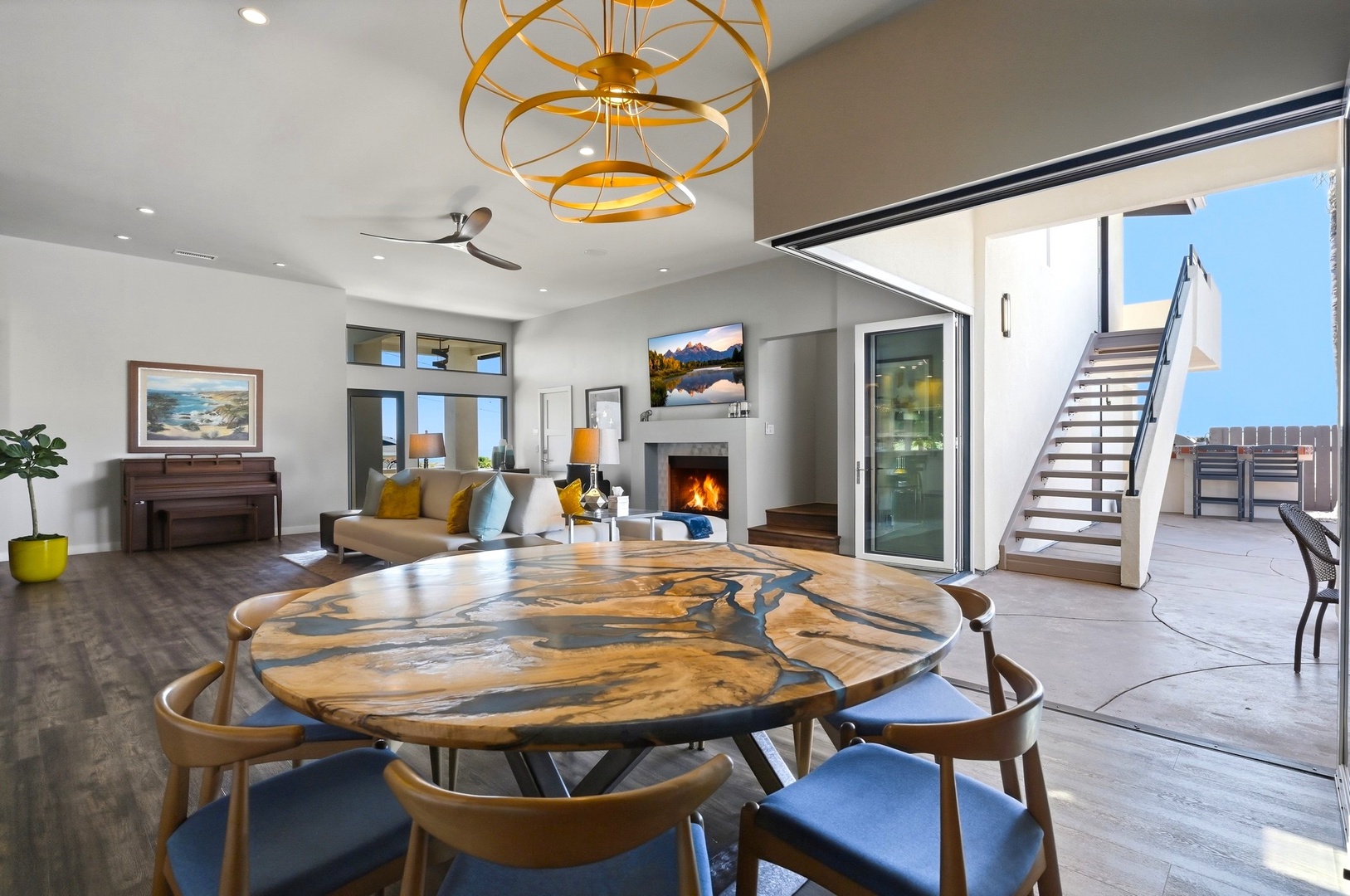 Gather around this stunning live-edge table in your elegant open-plan space, where modern design meets warmth beneath sculptural lighting.