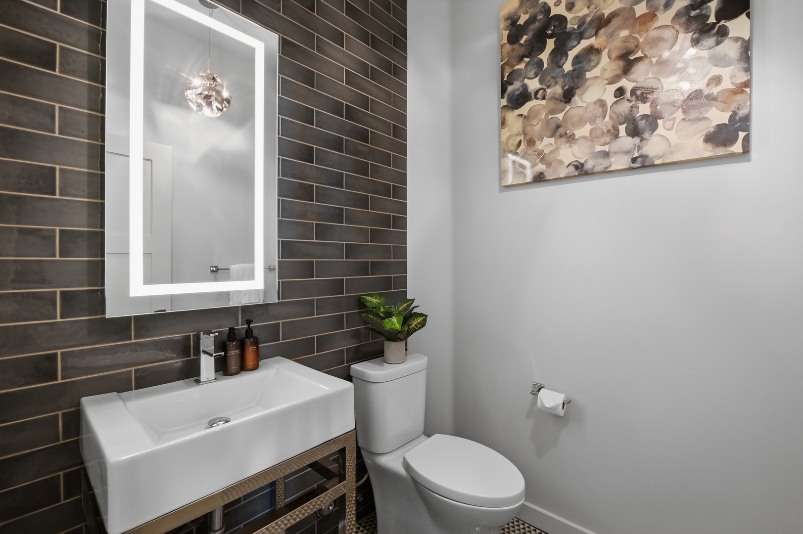 Freshen up in your stylish powder room featuring modern subway tile and thoughtful amenities.