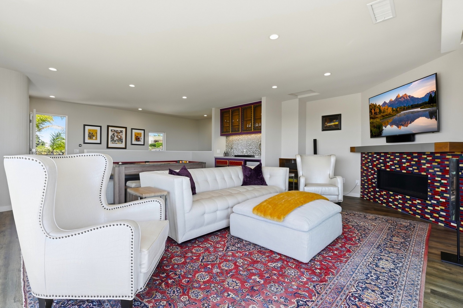 Unwind in your stylish living space with plush white seating, colorful fireplace, and mountain views on the wall-mounted TV.