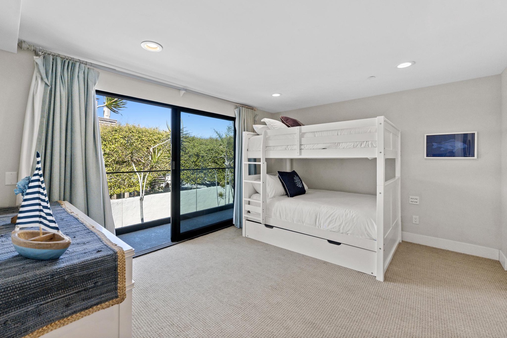 Your kids will love this bright, cheerful bedroom with white bunk beds and sliding glass doors opening to a private balcony overlooking lush tropical greenery.