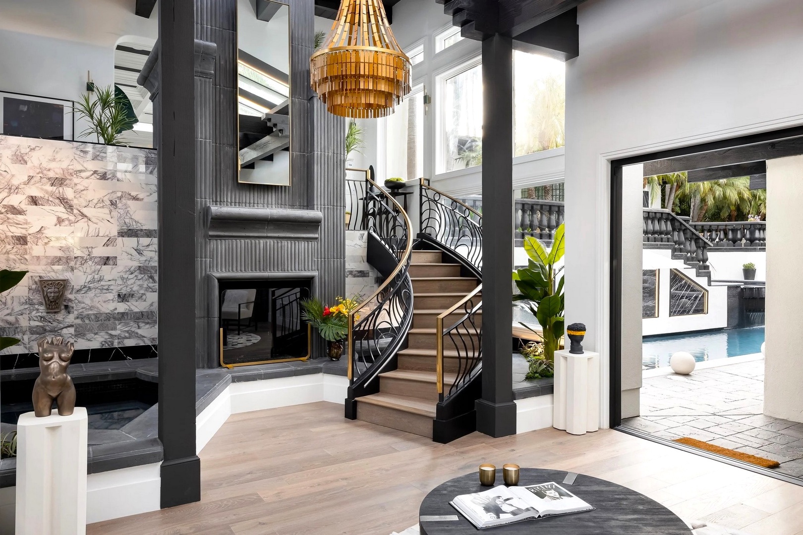 Step into a stunning living area where modern luxury meets classic elegance, with a dramatic spiral staircase and golden chandelier creating the perfect welcome.