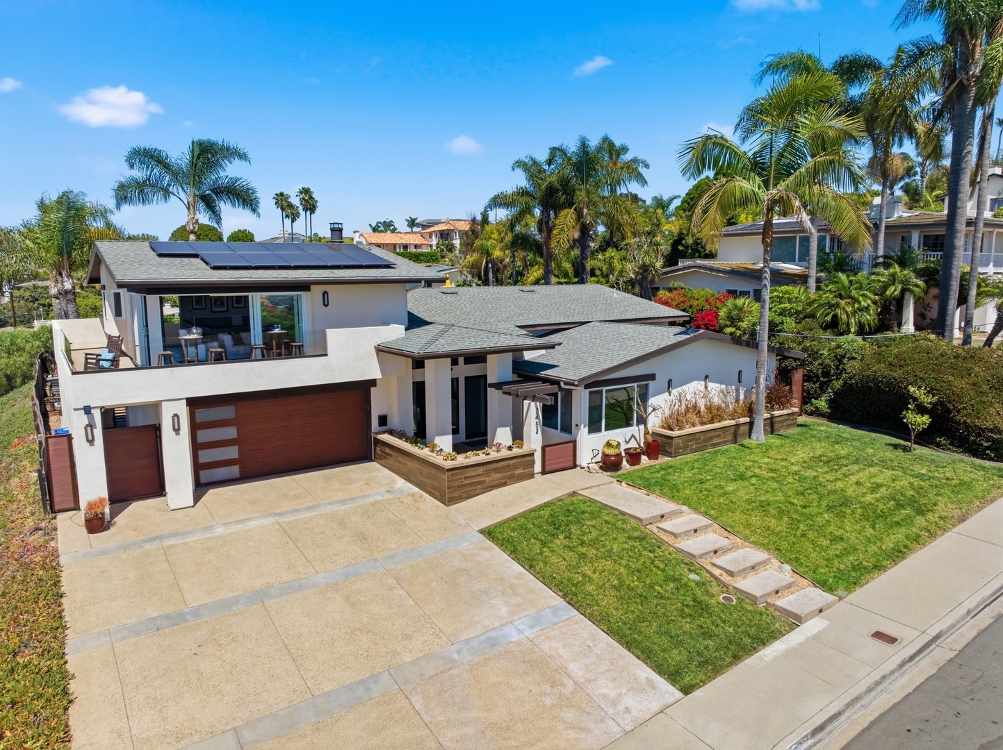 Modern coastal home surrounded by swaying palms in a peaceful residential neighborhood.