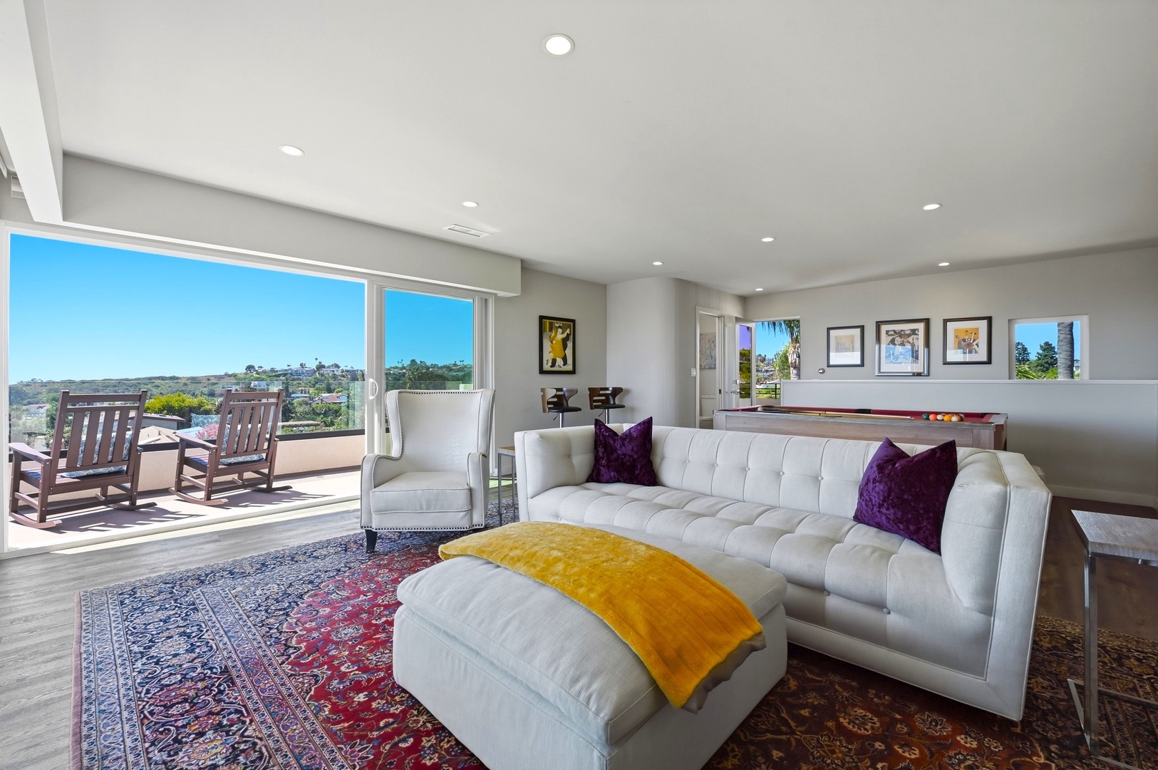 Sink into plush white leather seating while soaking up stunning city views through floor-to-ceiling windows that flood your stylish living space with natural light.