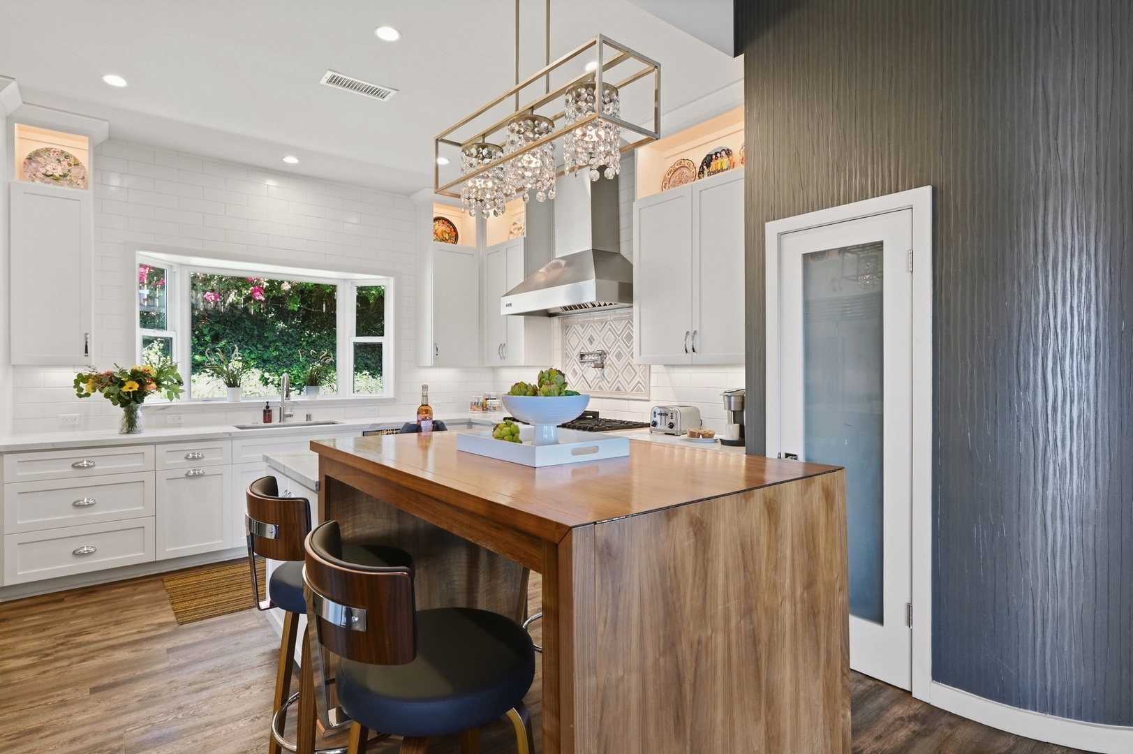 Your gourmet kitchen awaits with a stunning walnut island, gleaming countertops, and elegant lighting perfect for creating memorable meals together.