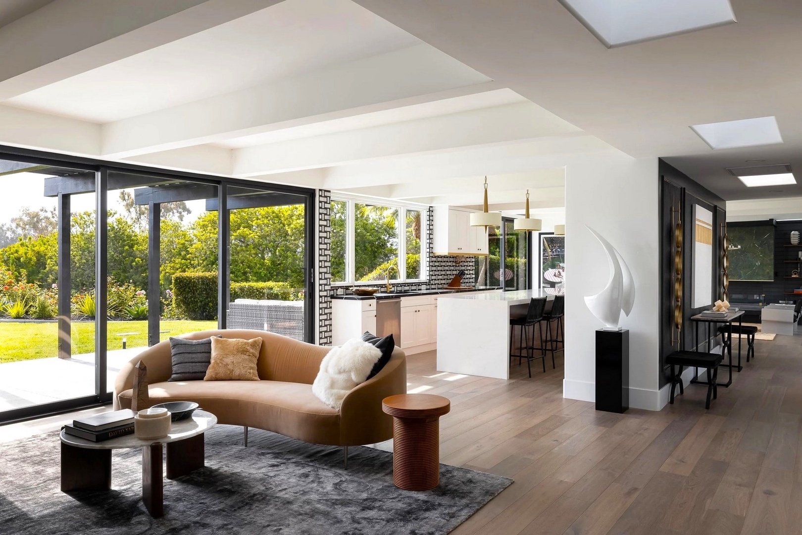 Relax in this stunning open-plan living space where floor-to-ceiling windows flood your retreat with natural light and garden views.
