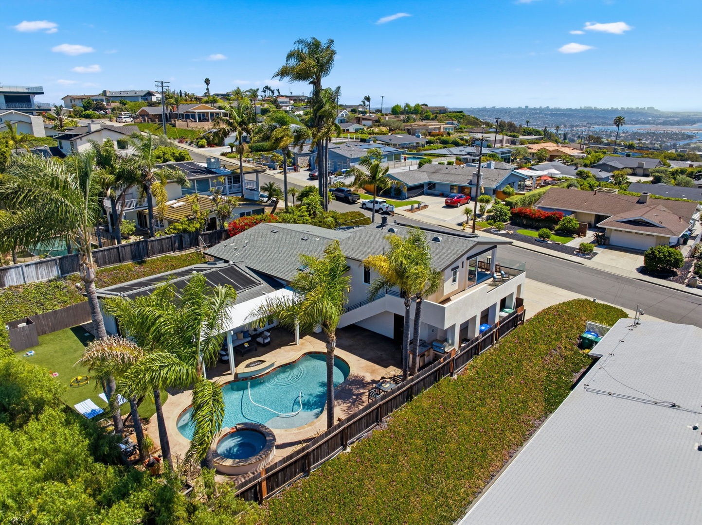 Aerial view showcases this stunning vacation home in a peaceful residential neighborhood, complete with private pool and tropical landscaping.