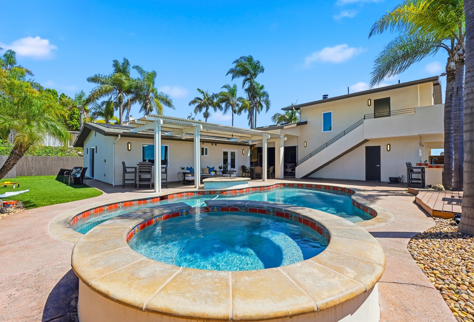Your private tropical oasis awaits with a sparkling pool and spa, surrounded by swaying palms and modern comfort.