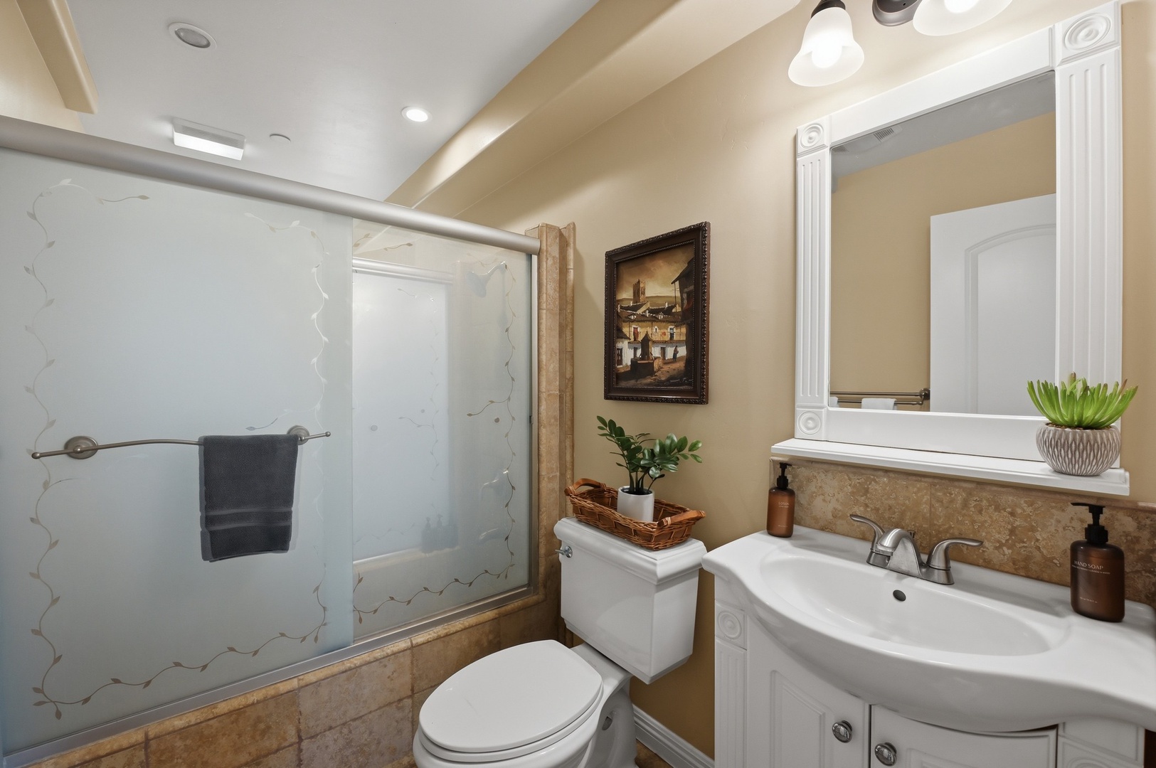 Step into your elegant bathroom featuring a luxurious glass shower, warm lighting, and thoughtful details like fresh greenery.