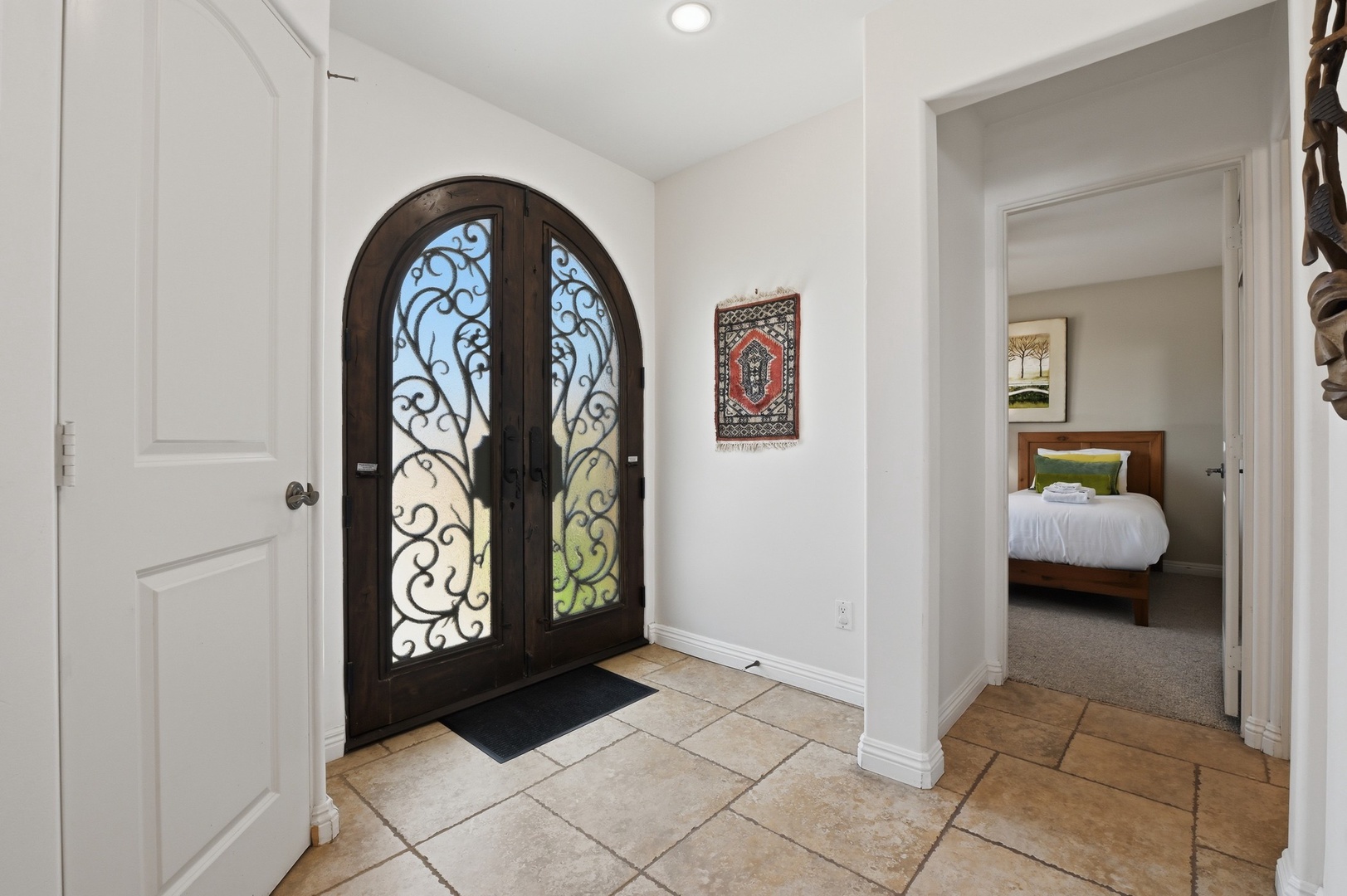 Step into your welcoming entryway with stunning arched glass doors and elegant tile flooring leading to comfortable bedrooms.