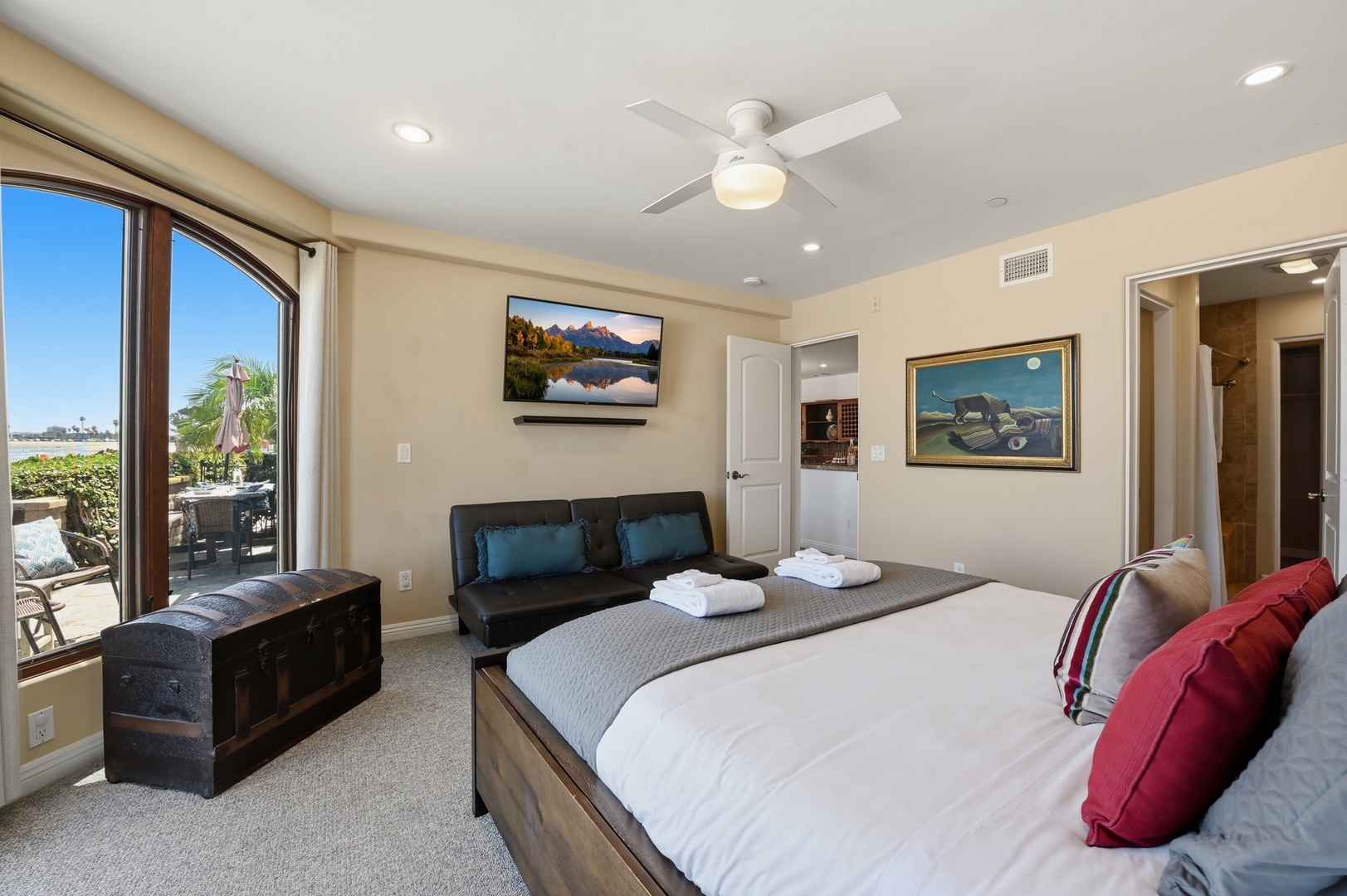Unwind in your spacious bedroom featuring a plush king bed, cozy seating area, and private patio access with scenic views.
