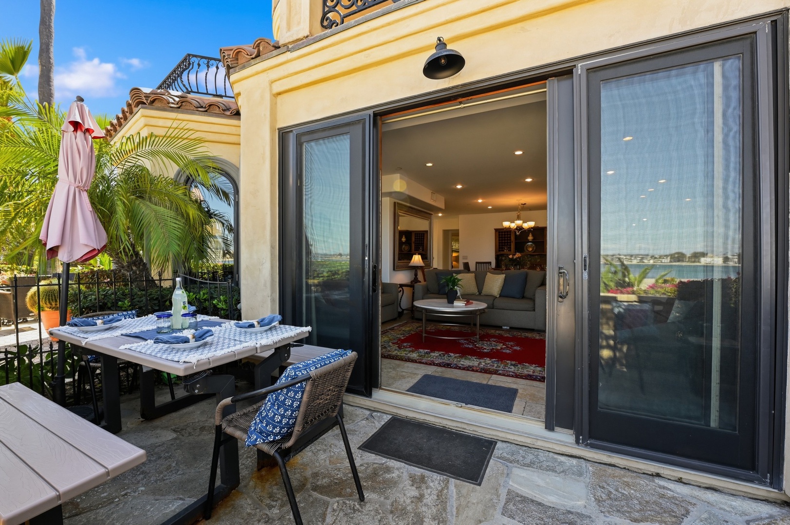 Step onto your private terrace where morning coffee awaits at the outdoor dining table, with sliding doors opening to your elegant living space.