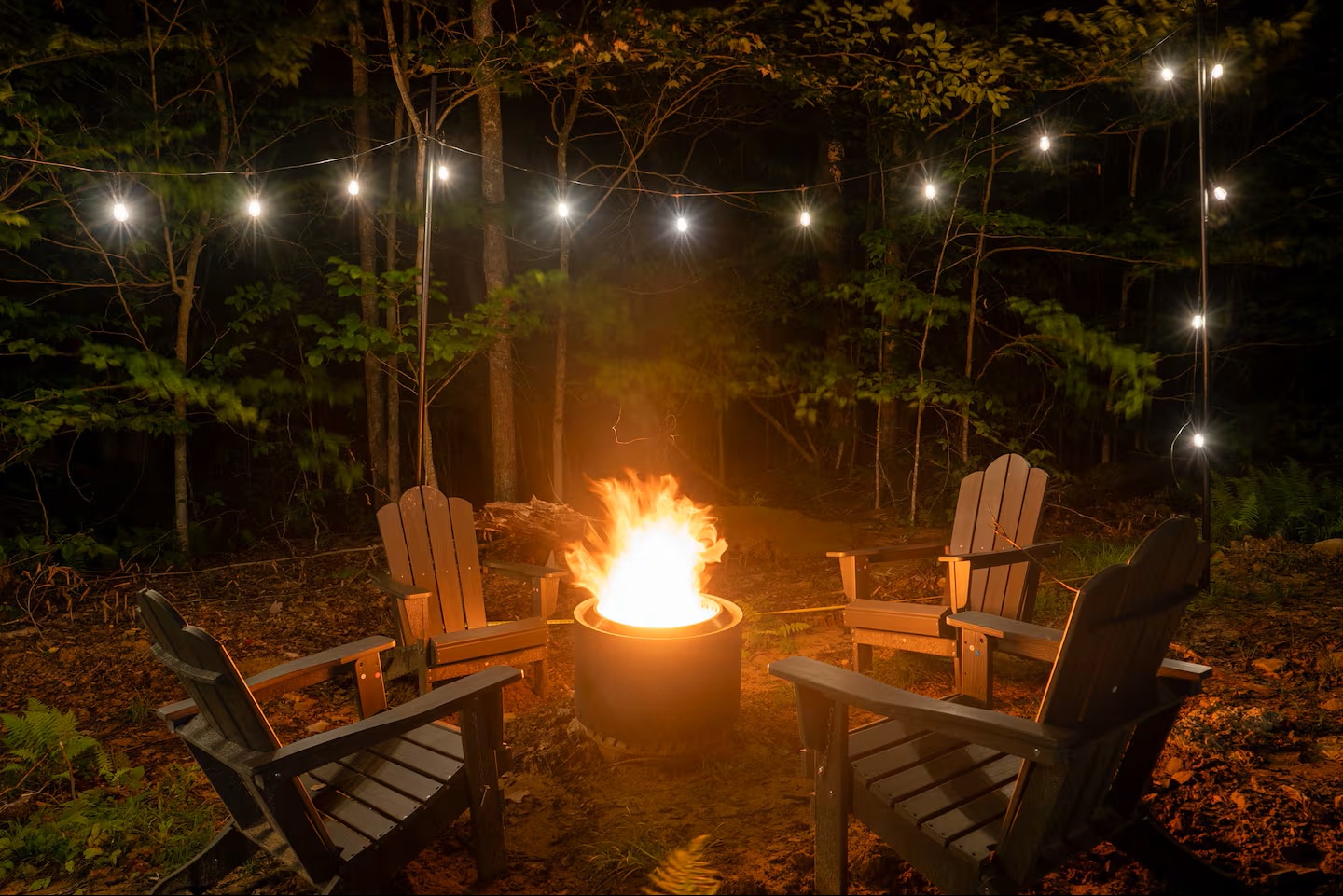 A crackling fire awaits under the stars, encircled by Adirondack chairs and twinkling lights strung through the trees. Perfect for sharing stories late into the night.